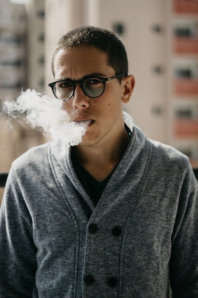 选择聚焦男人吸烟香烟白天的照片
